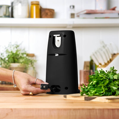Black can opener on a kitchen counter with a blurred background